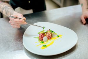 Chef preparing raw meat dish in kitchen Chef preparing raw meat dish in kitchen